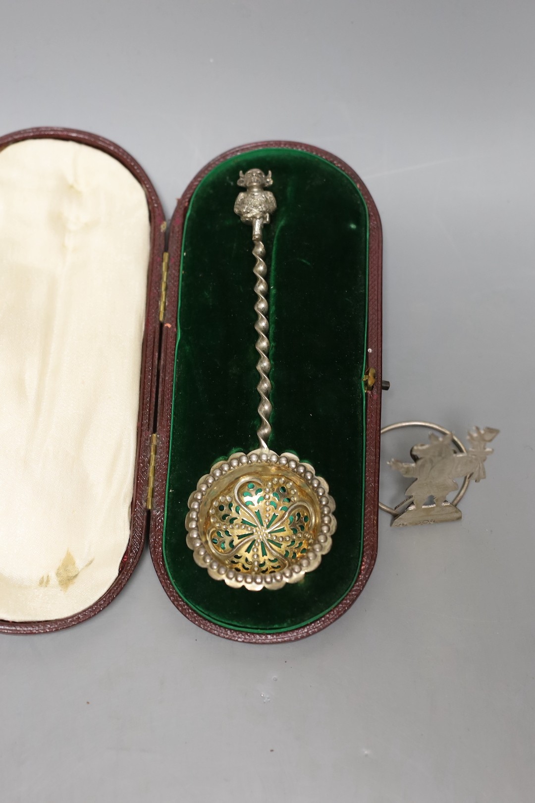 A George III silver helmet shaped cream jug, London, 1791, 13.2cm(a.f.), a silver menu holder and a cased silver sifter spoon.